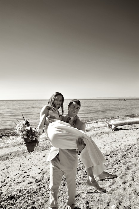 groom carrying bride at beach on lummi island near bellingham