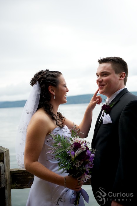 bride and groom by the ocean, joking and teasing each other. happy, outdoors, quirky