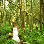 Smiling bride in old growth forest, looking at camera. Index, Washington.